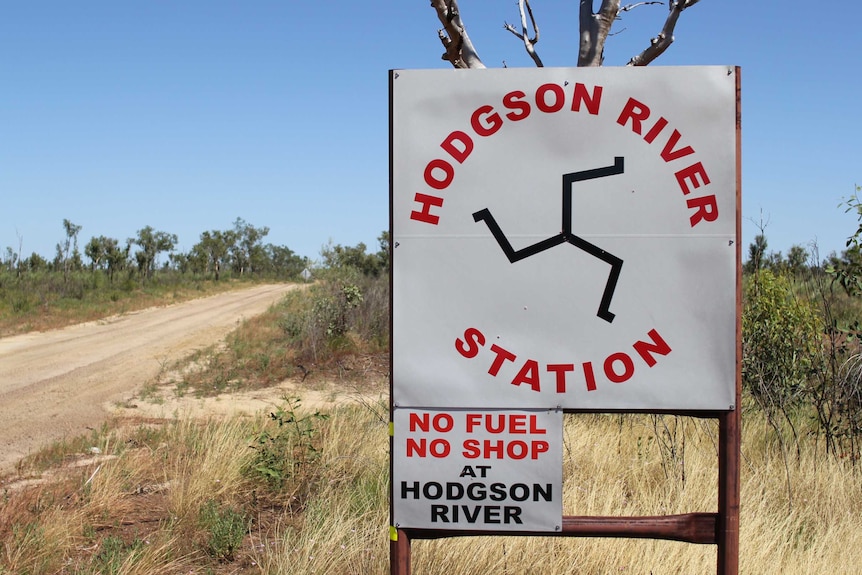 a sign for Hodgson River Station beside a dirt road.