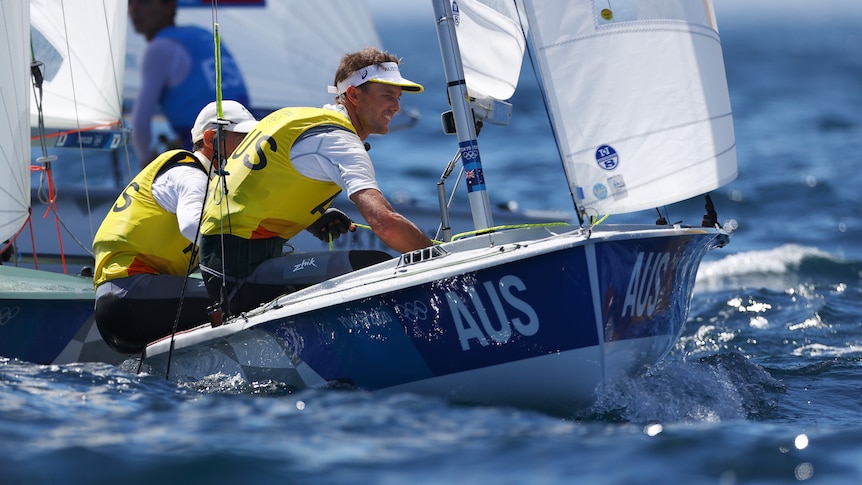 Two Australian sailors sit side by side as they race in the Olympics.