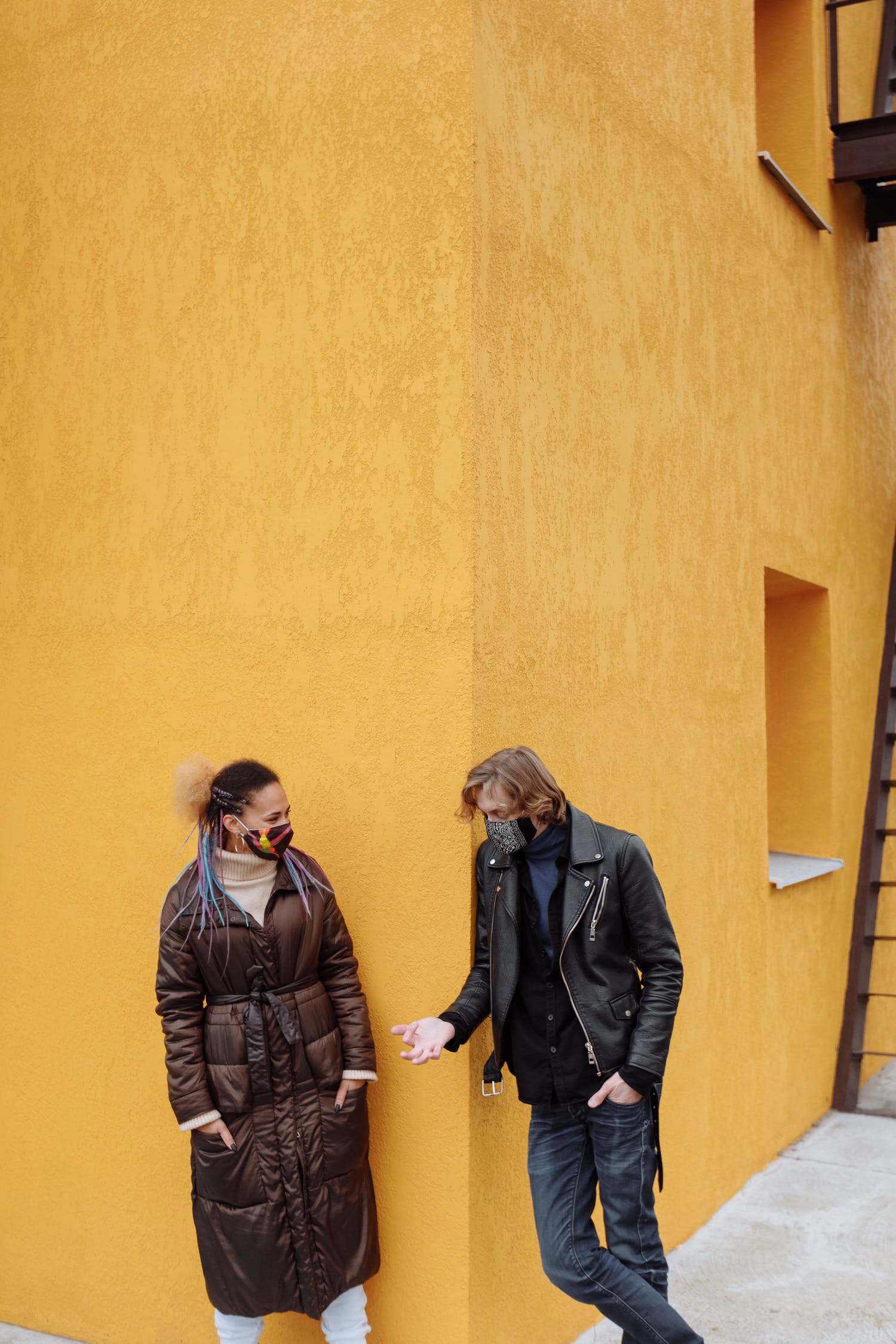 Two people talking wearing masks
