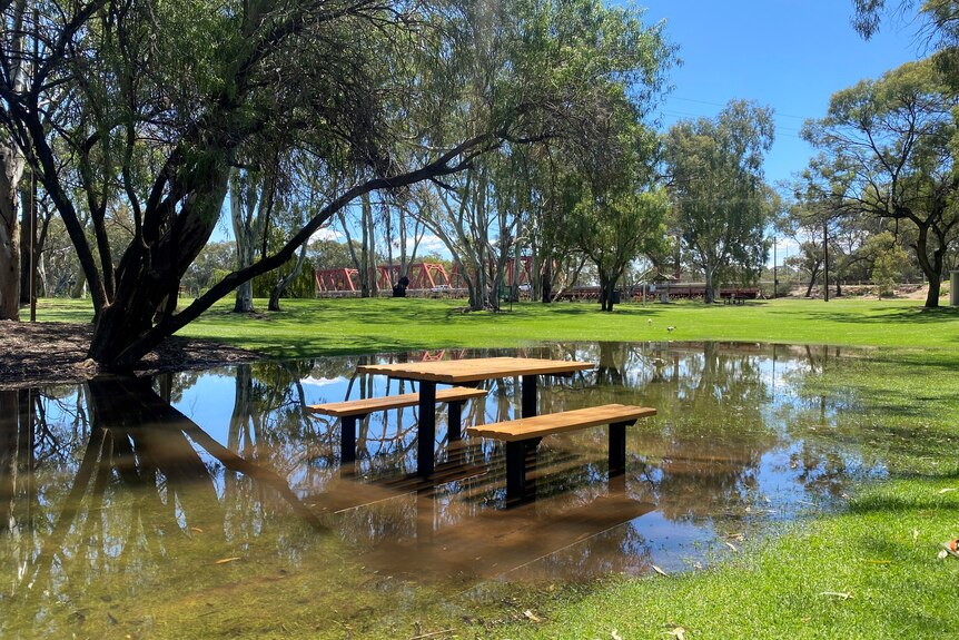 A park bench with water rising around it 