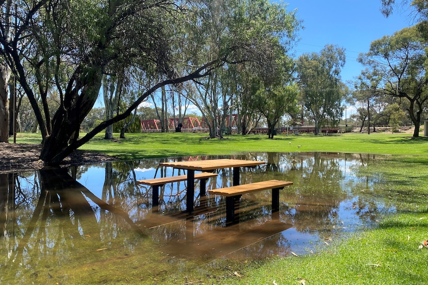 A park bench with water rising around it 