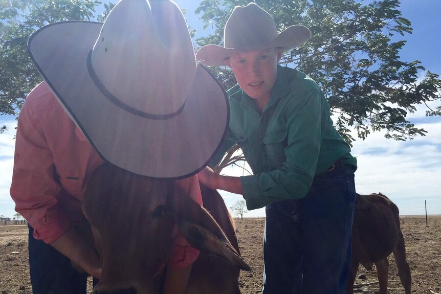 11-year-old Ruby Dyer and brother 12-year-old Sam hugging one of the poddy calves.