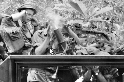 Australian troops fire an APC-mounted mortar during a sweep after the battle.
