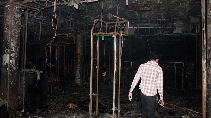 Police officer walks in burnt-out nightclub in Cambodia