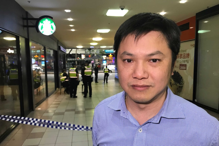 Peter Giang stands in a shopping mall.