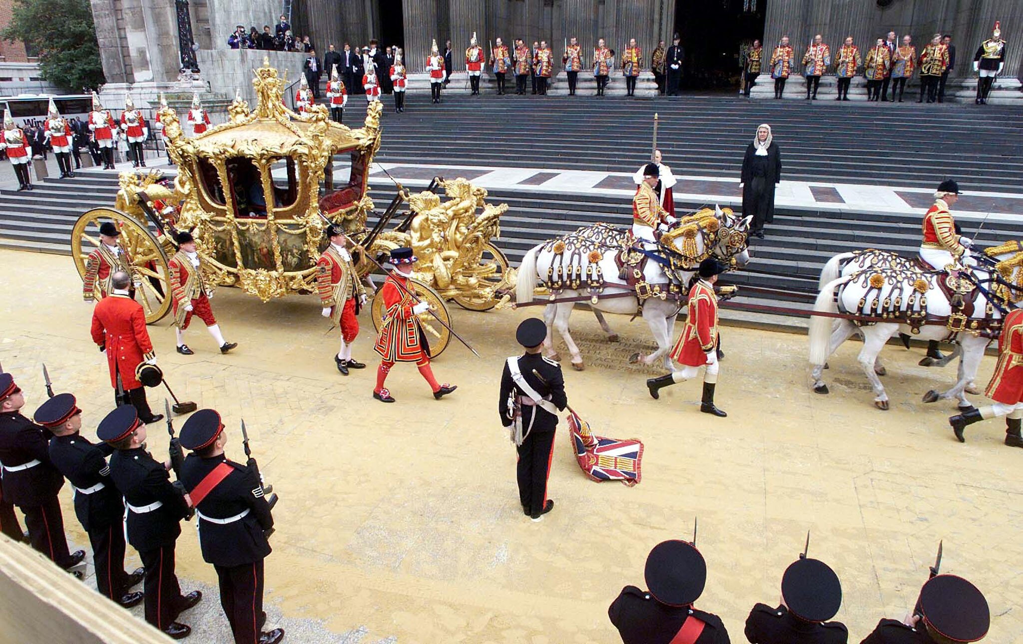 A golden coach pulled by white horses pulls up at St Pauls Cathedral