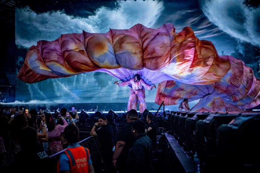 Un artista teatral sostiene un trozo de tela ondeante en el concierto de Taylor Swift en Sydney.