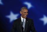 Barack Obama speaks at the lectern.