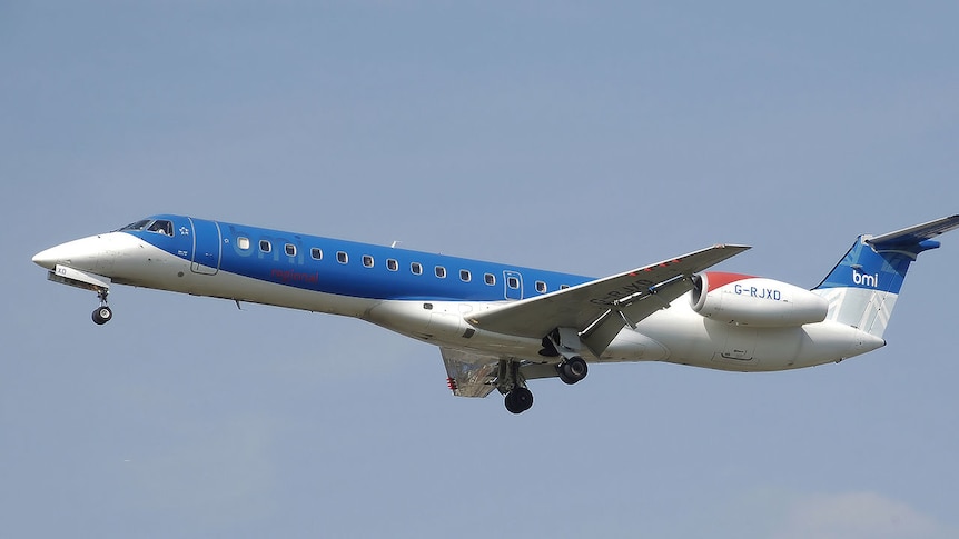An bmi plane flies against a blue sky.