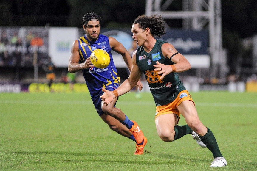 Cam Ilett chases the football in a St Mary's jersey as he is chased by a Wanderers player.