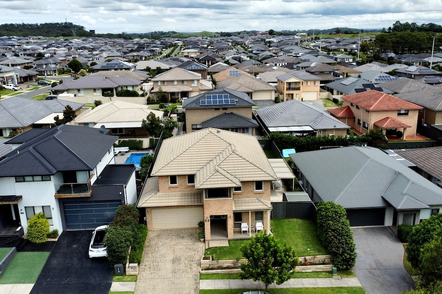 A drone shot of a new housing estate, with houses stretching as far as the eye can see