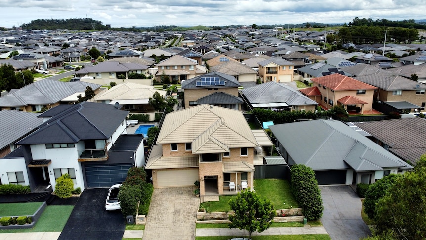 A drone shot of a new housing estate, with houses stretching as far as the eye can see