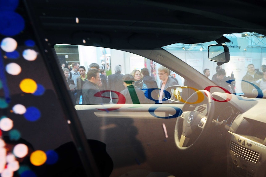 The Google logo is reflected in a window of a car equipped with special cameras for Google Street View.