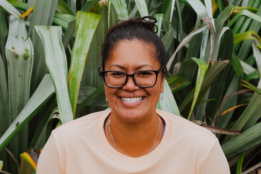 Moriori woman Hana Maraea with her dark hair tied back stands in a cane field