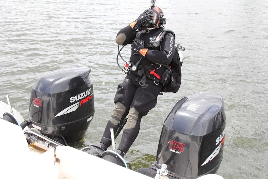 An ACT police diver prepares to enter Lake Burley Griffin.