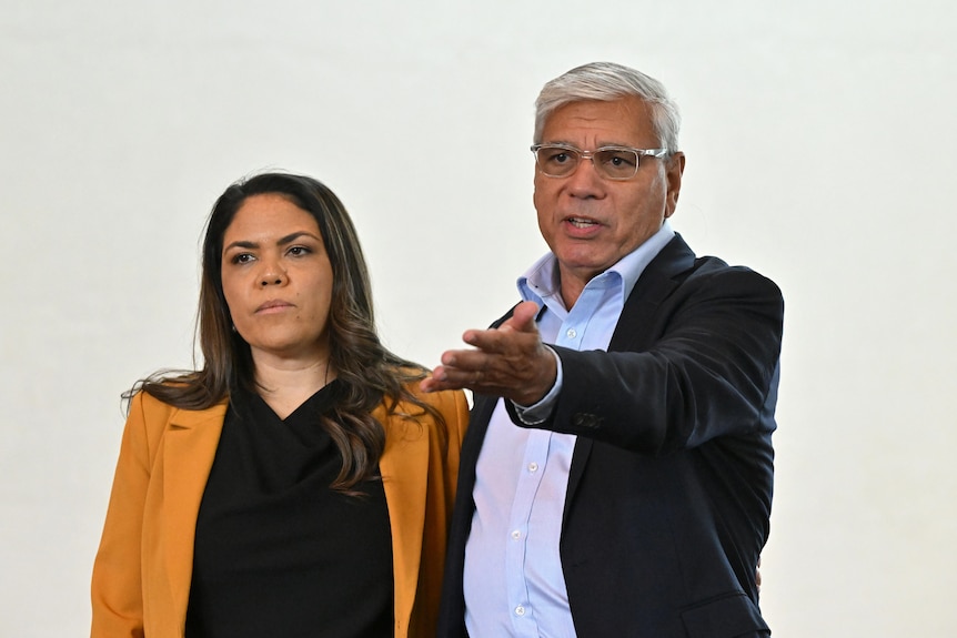 Jacinta Nampijinpa Price and Warren Mundine speak at a meeting. Mr Mundine has his arm out gesturing.