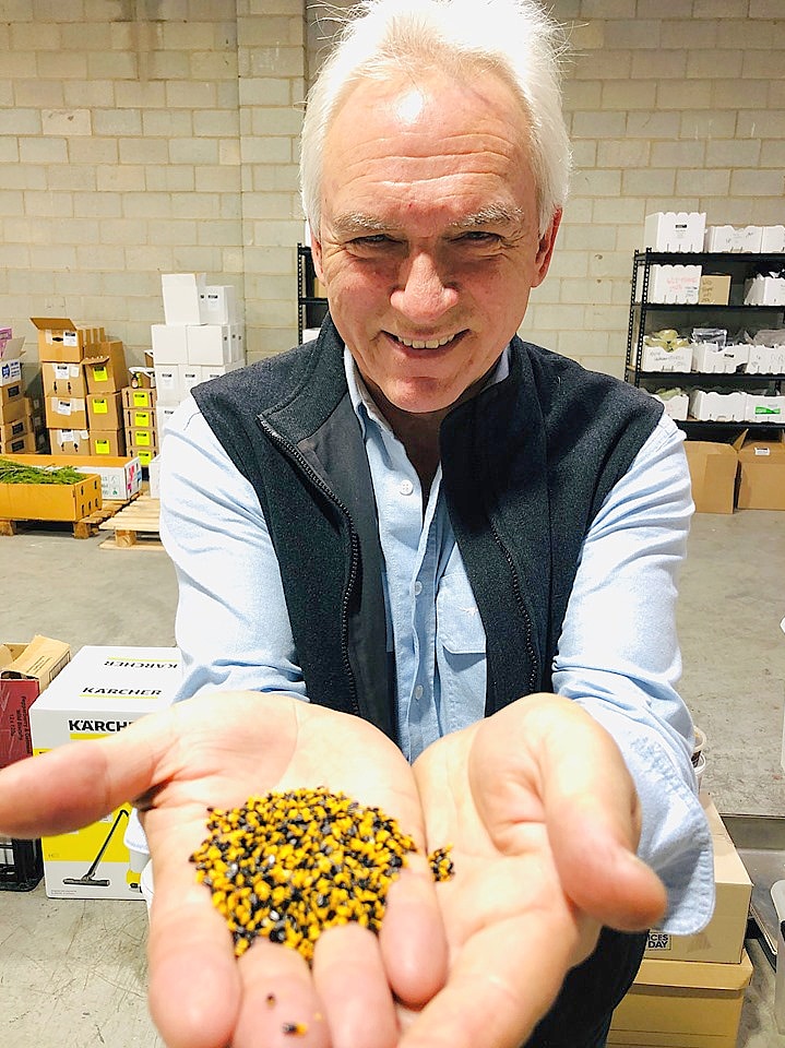 Chef Andrew Fielke holding wattle seed in his hands outstretched.