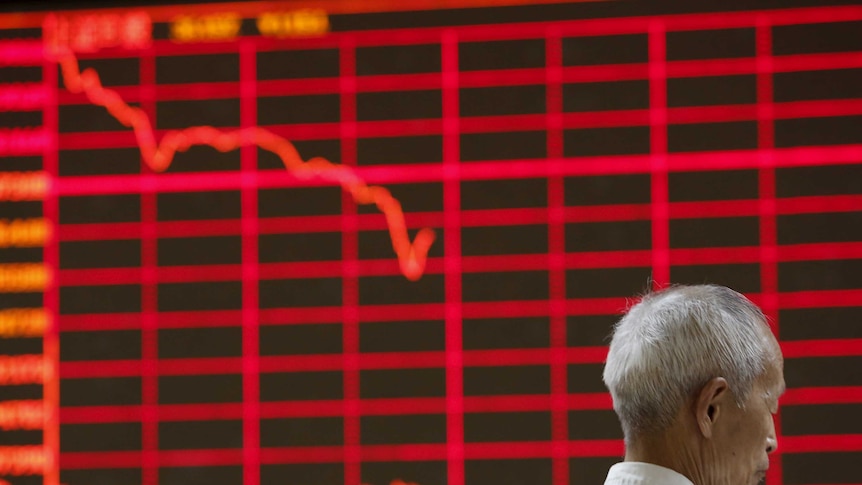 Man in front of electronic stock market board