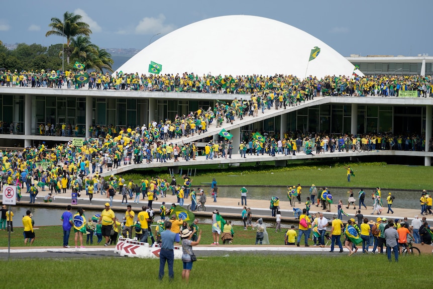 yellow and green clad people swarm ramps and building in brazil