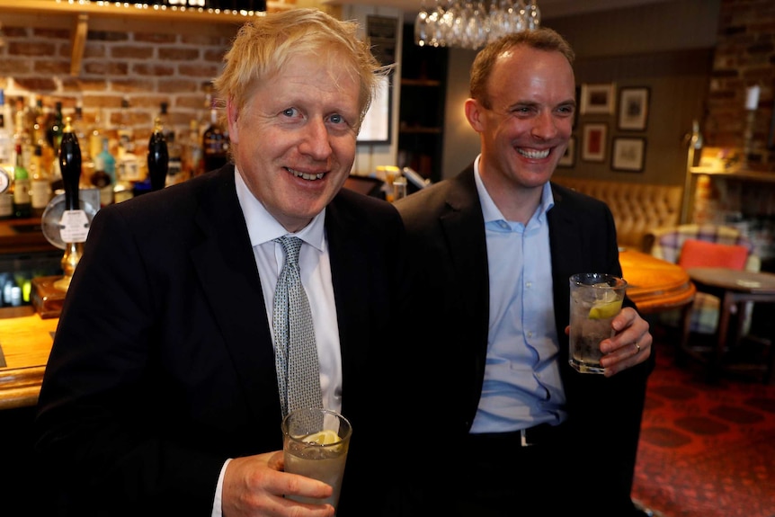 Boris Johnson and Dominic Raab holding drinks at a pub