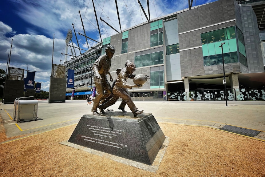 A bronze statue outside the MCG celebrating an early Australian rules football match.