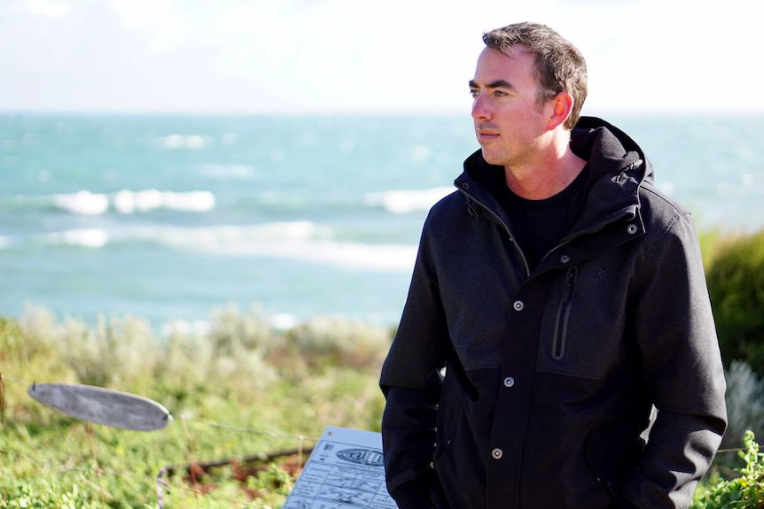 Rick Gerring standing on a hill with the ocean behind him