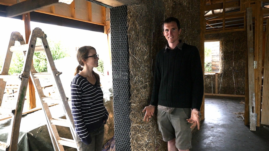Dani Austin and Sam Ryan stand in their straw bale home.