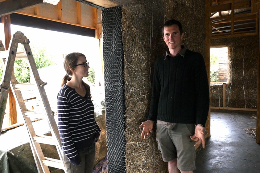 Dani Austin and Sam Ryan stand in their straw bale home.