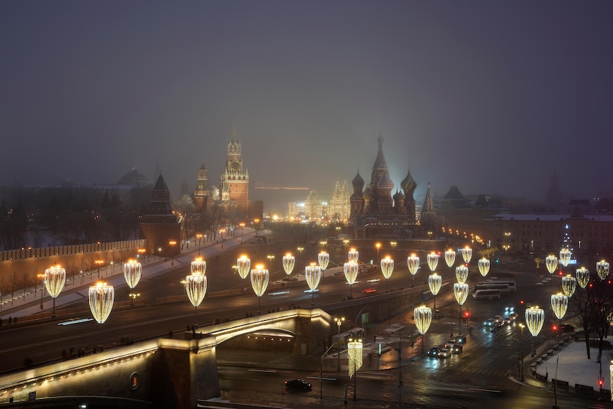 Moscow landmarks including the Kremlin Wall, Red Square, and St. Basil's Cathedral are lit up for Christmas