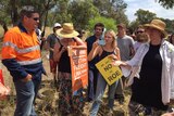 Roe 8 protesters and workers stand face to face in Bibra Lake.