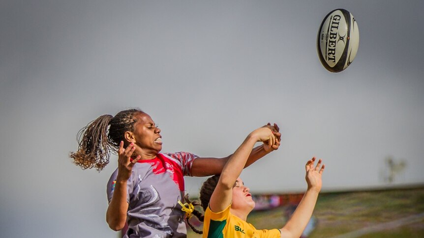 A New Caledonia player is lifted above her Australian competitor in a line out
