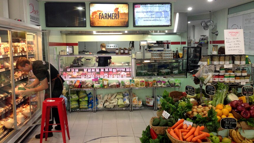 The shopfront at Shirralee Organic Butchery in Manly, with video screens above the counter showing films of farmers.