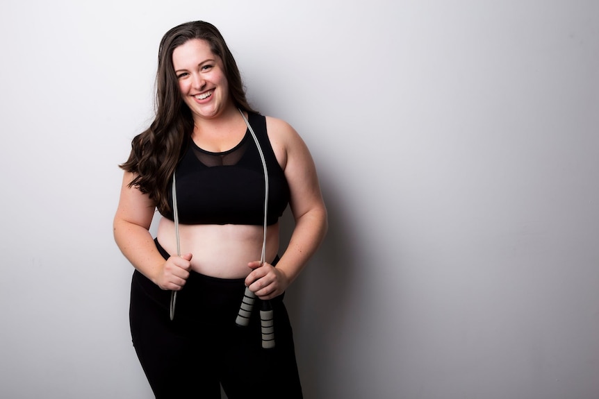 Personal trainer Natasha Korbut wearing exercise clothes and holding a skipping rope.