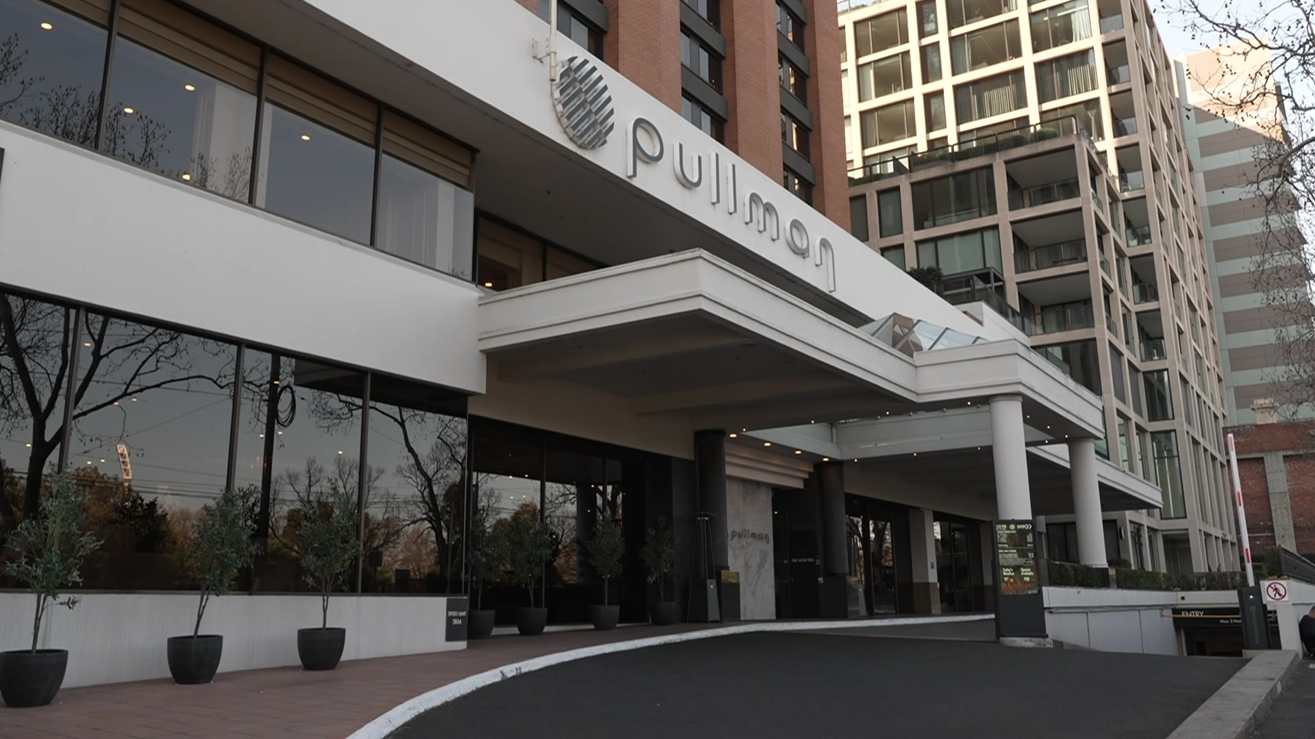 A driveway winds past a multi-storey building with a sign that says 