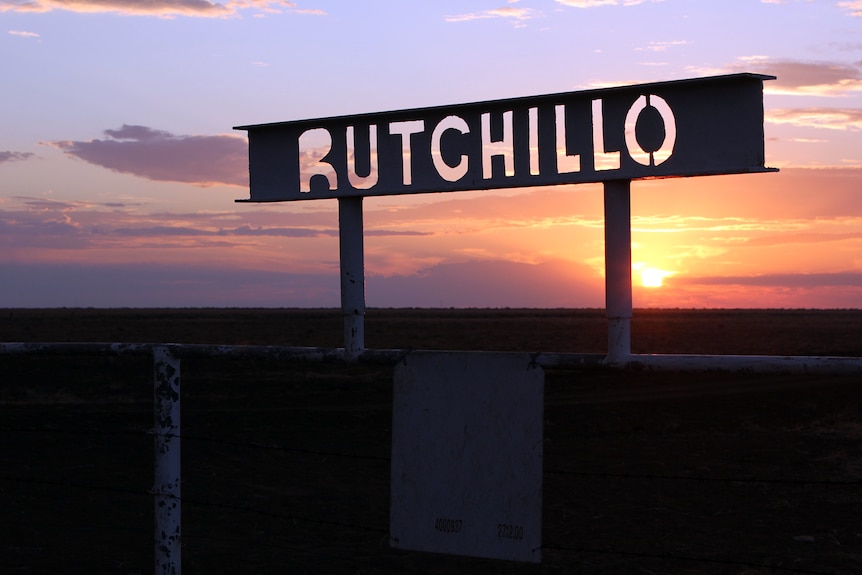 Sun setting behind tin cut out sign spelling Rutchillo