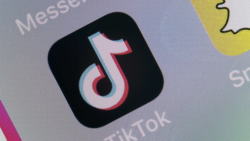 A close up of the TikTok logo on a phone screen. The logo looks like a musical note on a black background.