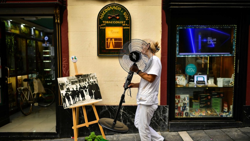 A woman carries a fan during a hot summer day, in Pamplona, northern Spain.