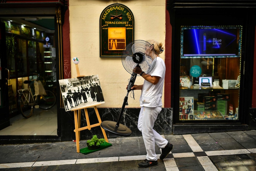 A woman carries a fan during a hot summer day, in Pamplona, northern Spain.