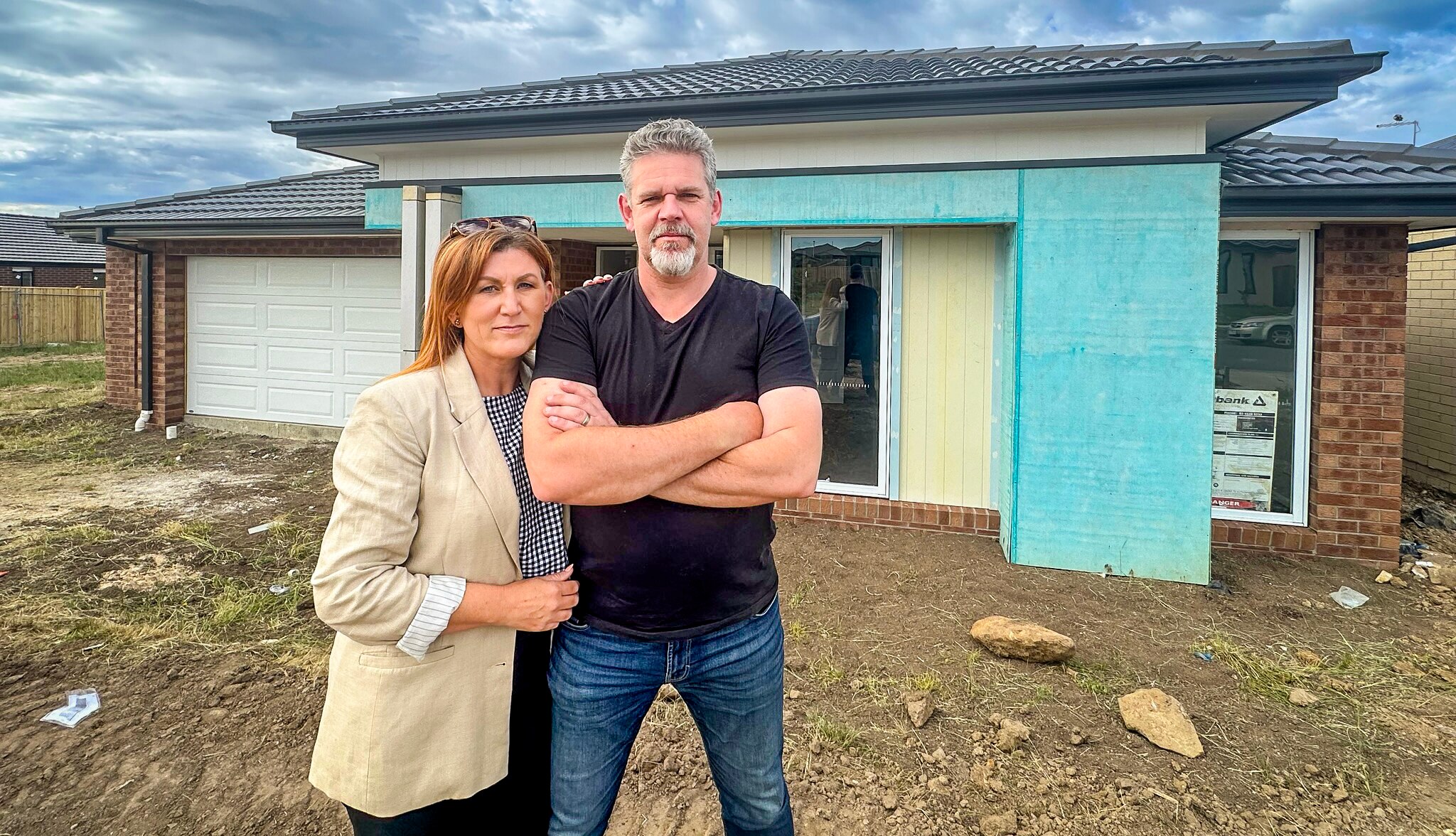 Travis McElroy and his wife Noeleen McKeag outside their home