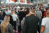A crowd of people waiting inside Sydney Airport