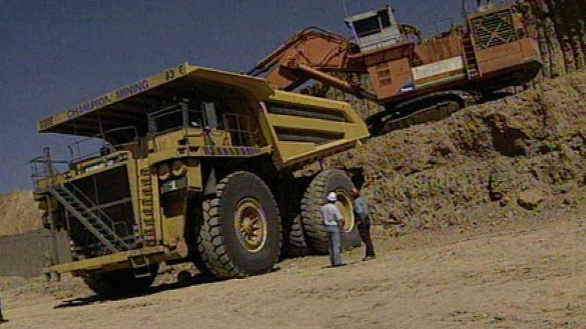 Workers at a mining site with a truck and excavator at an unidentified location in central-west Qld.