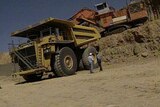 Workers at a mining site with a truck and excavator in central-west Qld.