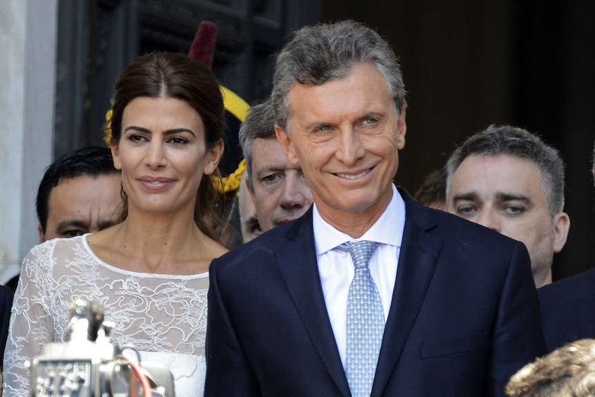 Mauricio Macri stands with his wife and smiles.
