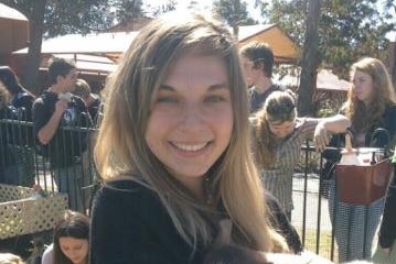 A young woman holds a pig at a petting zoo