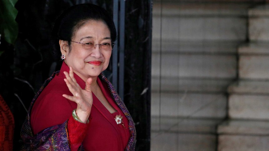 Former Indonesian President Megawati Soekarnoputri waves to reporters.