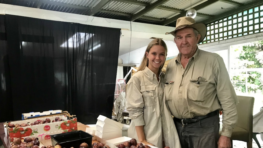 Peter Wise and his granddaughter behind a table of figs.