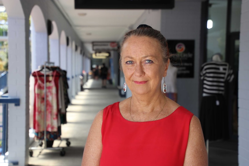 A woman standing in front of some shops