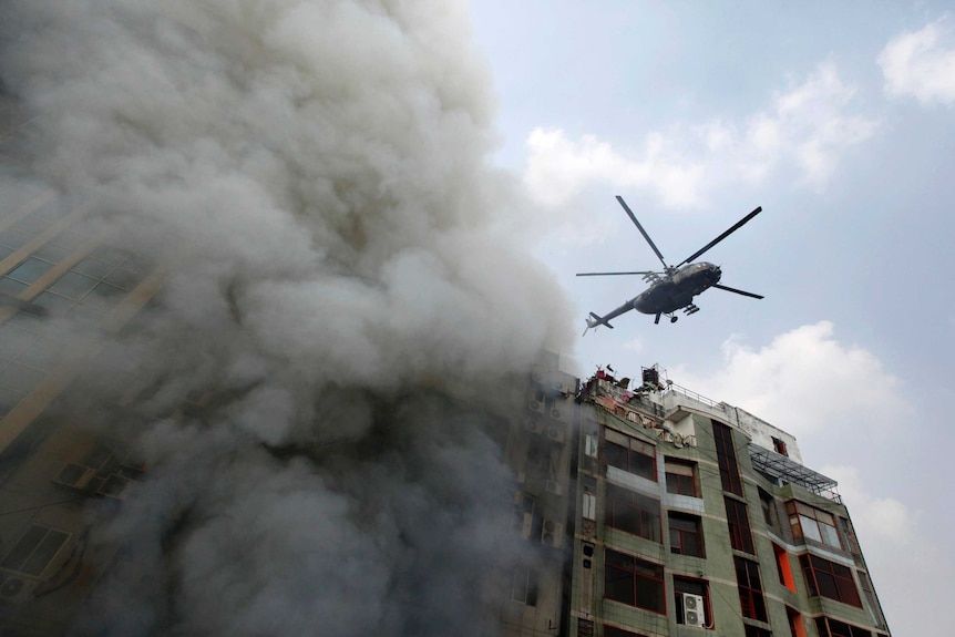 A chopper hovers to evacuate people stuck in a multi-storied office building that caught fire in Dhaka