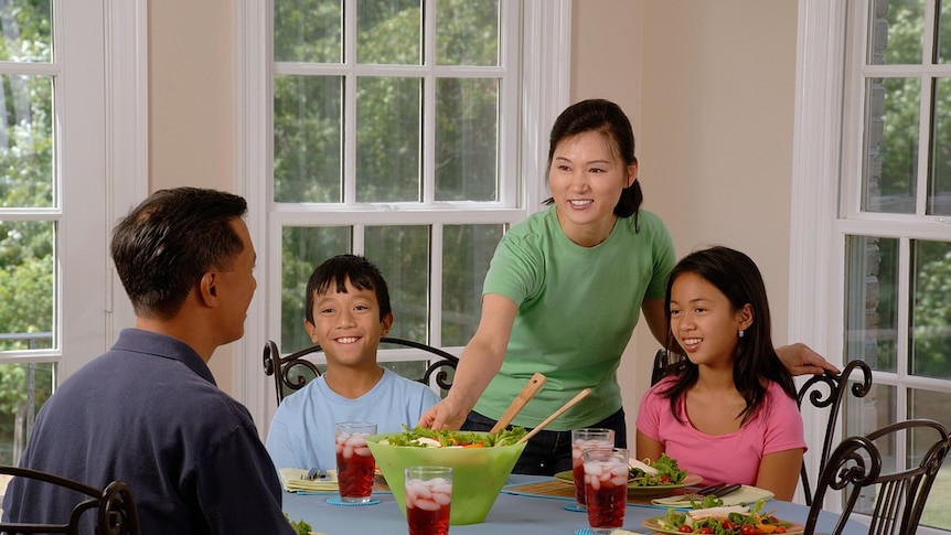 A family of four eating dinner at a dining table