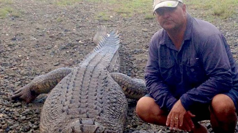 Cairns fisherman Jim Millar poses next to a headless three-metre crocodile